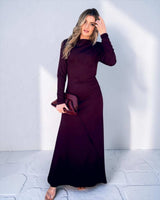 Woman wearing a burgundy long-sleeve dress against a white background