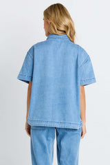 Back view of the Quinn Cotton Shirt in light blue denim featuring a relaxed fit and short sleeves.