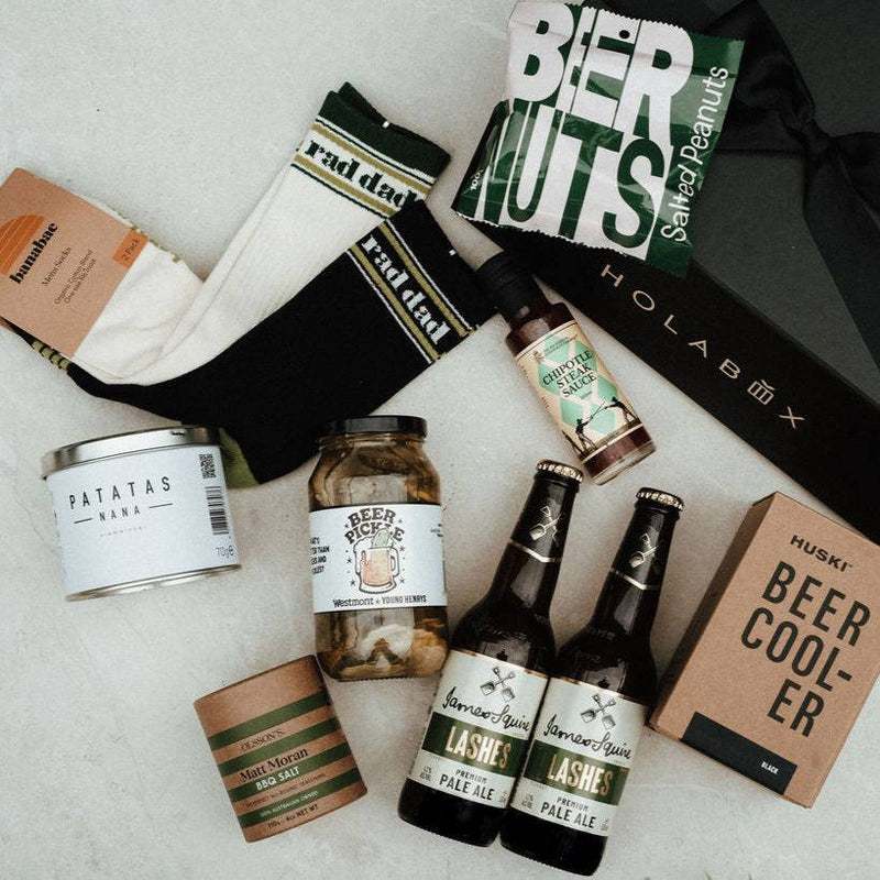 Collection of beer-themed items including bottles, a beer cooler, and snacks on a light surface.
