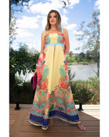 Woman in a colorful dress standing on a wooden deck with a scenic background