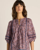 Alaia print cotton blouse with voluminous sleeves, pintuck detailing, and delicate lace inserts in a floral pattern.