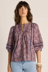 Alaia print cotton blouse with voluminous sleeves, pintuck detailing, and delicate lace inserts in a floral pattern.