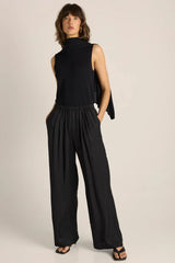 Model wearing a black Kora Cape Top in a luxe lightweight knit with a versatile, fluid cape detail.
