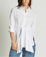 Woman wearing a white shirt with a tie waist against a plain background