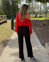 Woman wearing black high-waisted textured jersey pants with a straight-leg cut and invisible back zip closure.