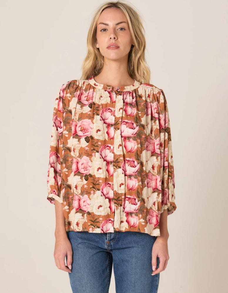 Woman wearing Sweet Emotions Top with floral print, balloon sleeves, and button-down front