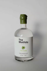 Bottle of The Plains Vodka by The Maltilda Distilling Company on a summer day with mangoes and hammock background