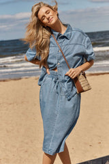 Model wearing a blue Quinn cotton shirt with a relaxed silhouette and button-through front on a beach.