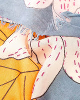 Bella Botanical scarf in blue with a bold, colourful floral print and frayed edges on a soft polyester blend fabric.