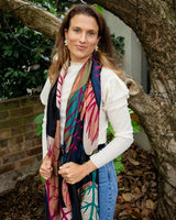 Chloe Abstract Forest scarf in black with pink and green tree patterns and frayed edges worn over a white top.