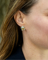 Daisy Delicate Pearly Stud Earring featuring white flower petals and a gold stamen centre worn on an earlobe.