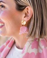 Olivia matte gold and light pink flower petal dangle earrings featuring a layered design on a model.