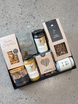 Gourmet grazing board in a box with cheese, olives, nuts, jerky, pickles, caramel onions, chocolates, and licorice for Father's Day gift