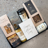 Gourmet grazing board in a box with cheese, olives, nuts, jerky, pickles, chocolates, and handwritten card for Father's Day gift