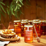 House of Holabox Ogilvie & Co 300g jar of mango-infused honey with a wooden dipper and toast on a wooden table