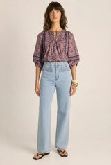 Alaia print cotton blouse with voluminous sleeves, pintuck detailing, and lace inserts worn with light wash jeans.