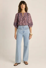 Alaia print cotton blouse with voluminous sleeves, pintuck detailing, and lace inserts worn with light wash jeans.