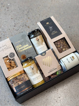 Gourmet grazing board in a box with cheese, olives, nuts, jerky, pickles, chocolates, and handwritten Father's Day card
