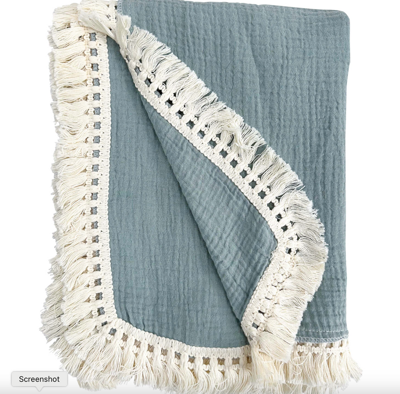 Blue textured blanket with white fringe on a white background