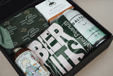 Gift set with beer-themed items including socks, a bottle, and a can in a box.