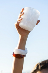 Hand-carved white Himalayan salt margarita glass held against a clear sky.