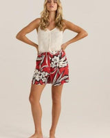 Woman wearing red floral print viscose-linen shorts with a flat front, belt loops, and side pockets.
