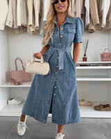 Indigo denim midi dress with a button-down front, puff sleeves, belted waist, and side pockets in a walk-in closet.
