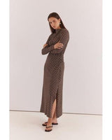 Model wearing a brown long-sleeved midi dress with white polka dots, high neckline, and side ruched detailing.