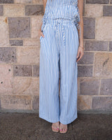 Blue and white striped wide-leg trousers with a drawstring waist, paired with a matching gathered tie-side top.