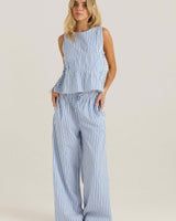 Blue and white striped sleeveless top with adjustable side ties and asymmetric gathering, paired with matching trousers.