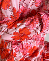 Soft pink stretch jersey pyjama set featuring a vibrant red and pink floral print with contrast piping detail.