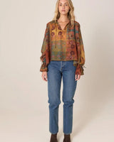 Bohemian long-sleeve top in a floral patchwork print with a keyhole tie neck, drop shoulders, and frilled elastic cuffs.