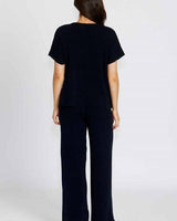 Woman wearing navy blue Bonnie pants and matching top in comfortable cotton viscose fabric, shown from the back.