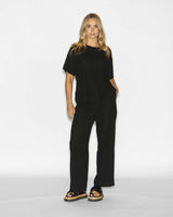 Model wearing comfortable black cotton viscose Bonnie pants with a matching black t-shirt and sandals.