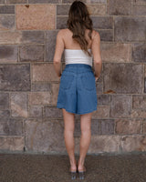 Woman wearing relaxed-fit blue denim shorts with an elasticated back waistband and back pockets.