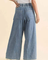 Back view of light wash denim joggers with an elasticated waistband and large back pockets.