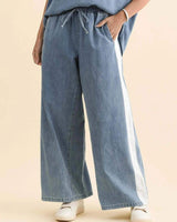Blue denim joggers with an elasticated drawcord waist, side pockets, and a white side stripe in a relaxed fit.