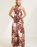 Cartez high neck jumpsuit in a brown and cream floral print with a waist cut-out and wide-leg silhouette.