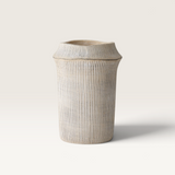 Catullo Vase in sand-toned concrete with a tall tapered shape, fine vertical ribs, and a flared rim.