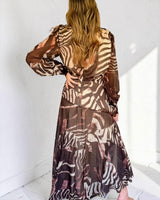 Chantelle maxi event dress in chocolate brown with a flowing, long-sleeved silhouette and abstract zebra print.