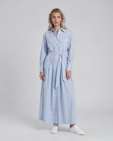 Woman wearing a light blue striped dress on a white background