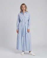 Woman wearing a light blue striped dress on a white background
