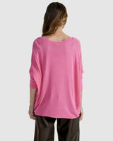 Back view of a pink Clarity Knit sweater with a boat neckline, dropped shoulders, and a relaxed hi-low hem.