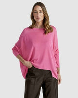 Bright pink Clarity Knit sweater featuring a boat neckline, dropped shoulders, and a relaxed hi-low hem with side splits.