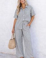 Woman wearing wide-leg Clementine pants in a breathable black and white vertical stripe cotton-viscose blend.