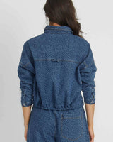 Back view of a blue denim cropped jacket with a subtle tonal leopard print pattern and a relaxed, structured fit.