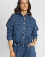 Model wearing a blue denim cropped jacket with a subtle leopard print, button-down front, and chest pockets.