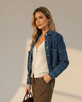Woman wearing a structured blue denim cropped jacket with button-down front and relaxed fit.