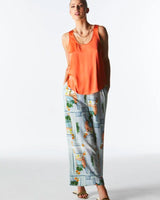 Dashing tank in vibrant orange silk-blend with a scoop neckline and thick straps, styled with patterned trousers.