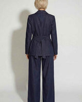 Back view of a dark denim Destiny blazer with a tie-waist belt and matching wide-leg trousers.